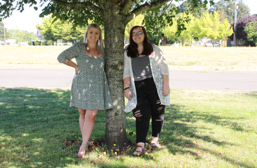 Mentor and mentee smilling underneath a tree