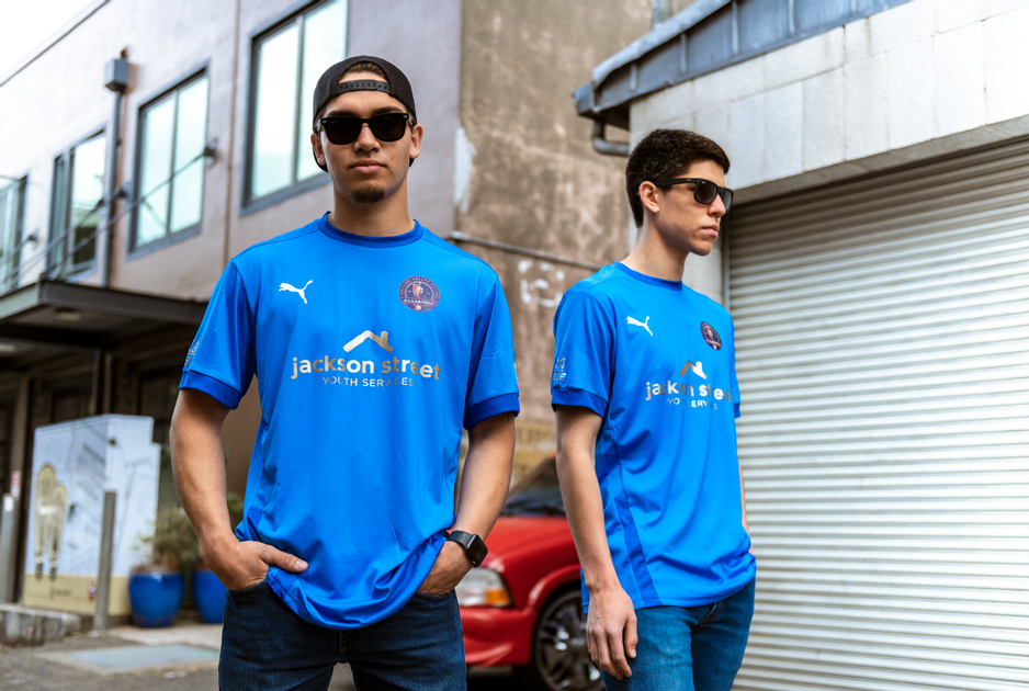 Two folks in sunglasses wearing a jersey with the Jackson Street logo on the front.